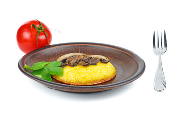 Red tomato, fried mushrooms, and polenta piece on brown ceramic plate. Isolated on white background