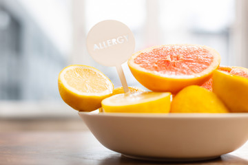 Lemons and grapefruits in little white bowl standing near window