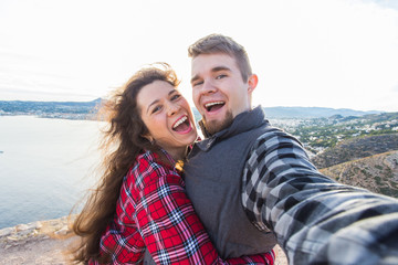 Travel, vacation and holiday concept - Beautiful couple having fun, taking selfie, crazy emotional faces and laughing.