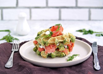 Light dinner, lunch or lunch, savory spinach snack waffles with salted salmon and cream cheese on a ceramic plate