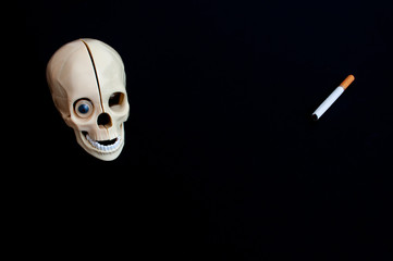 skull with cigarettes on black background