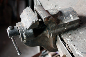 Old vice on the workbench in the workshop.