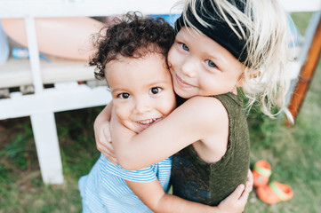 Two happy little boys hug each other
