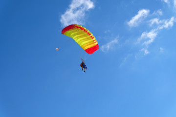 A parachute is in the blue sky.