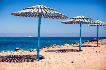 Sun umbrellas on a beach with sea background. Summer and vacation concept