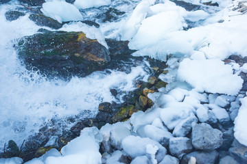 Frozen water channel. Mountain river in winter. Icing on the bank of the stream. Bypass channel....