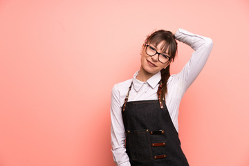 Young waitress over pink background laughing