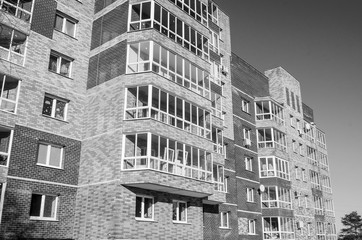 The new nine-storey house, illuminated by sunlight, is depicted in a sharp angle from the level of...