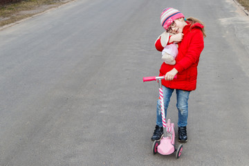 girl riding a scooter in the spring on the road in the city