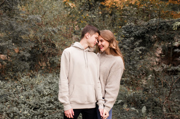 Happy teen couple 15-16 year old looking at each other outoors. Spring season.