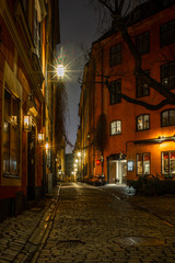 Fototapeta na wymiar Old cobbled narrow street in Stockholm at night