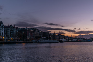 Fototapeta premium Ships in the harbor of Stockholm during a colorful sunrise in winter with the backdrop of the Old Town - 1