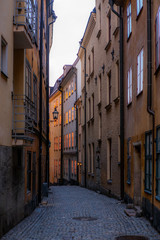 Fototapeta na wymiar Old cobbled narrow street with colorful houses in Stockholm in the morning - 10