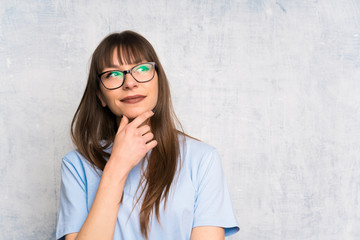 Young woman on grunge background thinking an idea