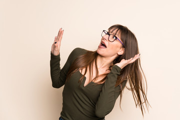 Young woman on ocher background nervous and scared
