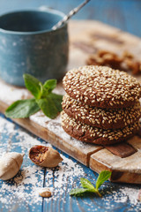 Chocolate cookies with sesame seeds on the wooden board.