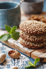 Chocolate cookies with sesame seeds on the wooden board.