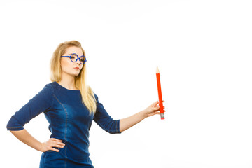 Serious woman holds big pencil in hand