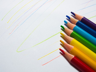 colored pencils, seven colors of the rainbow, on a white background with color lines