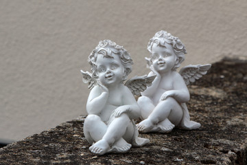 Two miniature angels on a stone wall