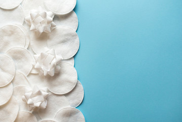 Cotton pads with white flowers for removing makeup on a blue background close-up. copy space. place for text