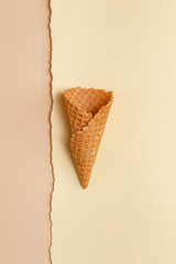 Waffle cone for ice cream on a paper background. Top view. Copy space. Minimalistic concept.