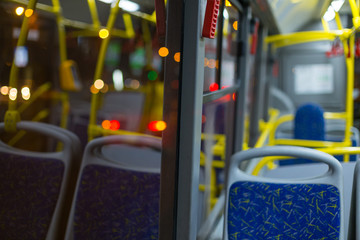 the bus is empty in the evening, street lights are on