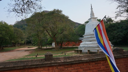 Pagoda at sigiriya in sri lanka with the Buddhist flag.