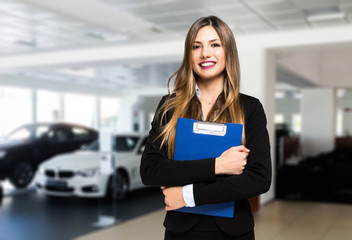 Saleswoman with folder and auto show background