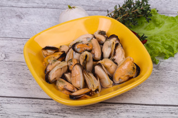 Pickled mussels in the bowl served pepper, garlic and salad