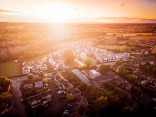 Sunset over traditional British houses with countryside in the background. A picturesque scene, created by the long shadows and warm glow