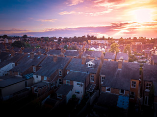 Sun rising above a traditional British housing estate with countryside in the background.  Very...
