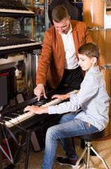 Father and son are looking  keyboard