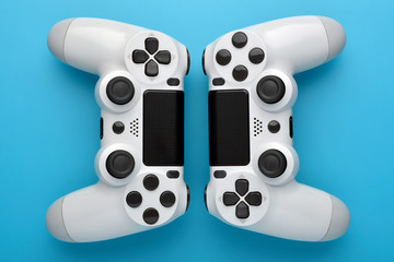 Two game controllers on blue background. Game concept. Competition concept. top view.