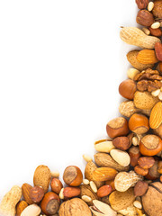 Background of mixed nuts - hazelnuts, almonds, walnuts, pistachios, peanuts, pine nuts peeled and not peeled - vertical with copy space. Isolated one edge. Top view or flat lay