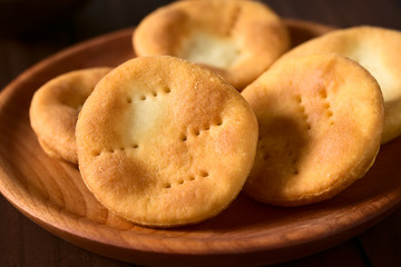 Traditional Chilean Sopaipilla fried pastries made of a bread-like leavened dough served on wooden...