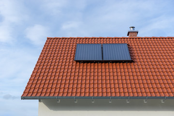 solar panels on roof of house with red tiles