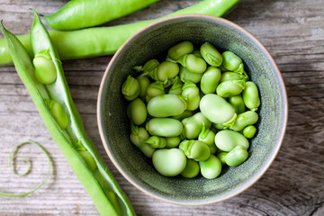 Fresh broad beans on the wooden board