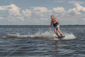 Tense man wakeboarding in a lake and pulled by a boat