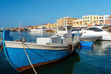 Fototapeta na wymiar Traditional greek motorboat is moored near the pier. Crete island, Greece