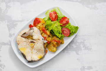 boiled fish with salad on white dish