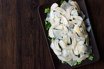 Homemade Fresh Artichoke Salad with Arugula, Rucola or Rocket Leaves on Dark Wooden Surface.