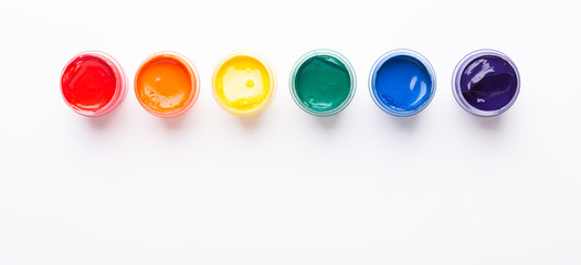 Six jars of paint on a white background Isolated Multicolored gouache Top view