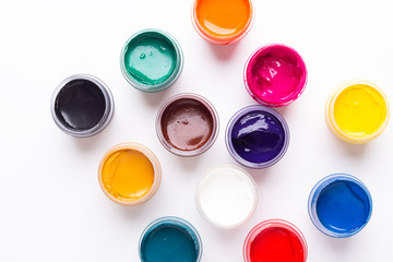 Multicolored gouache on a white background Isolated Paints in containers Top view