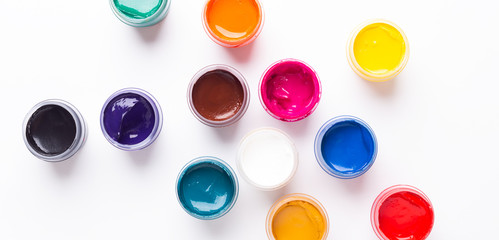 Multicolored gouache on a white background Isolated Paints in containers Top view Banner Horizontal