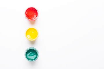 Red, yellow, green gouache on a white background Isolated Paints in containers Top view Traffic light