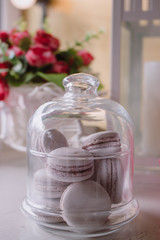 Pink french macarons under the glass on the wooden boards, soft focus background. Sweet desert In the local cafe.