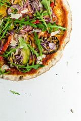 half pizza with vegetables arugula on white background