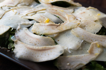 Homemade Fresh Artichoke Salad with Arugula, Rucola or Rocket Leaves on Dark Wooden Surface.