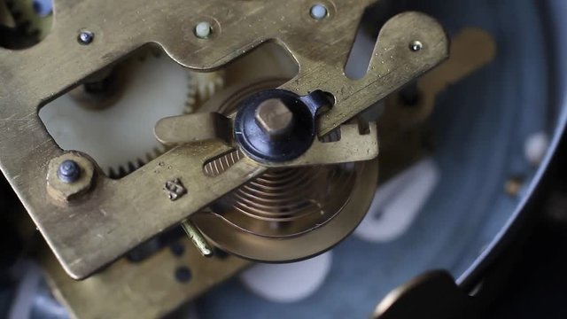 Old vintage clock mechanism working, closeup shot with soft focus. Close up of a internal clock mechanism.